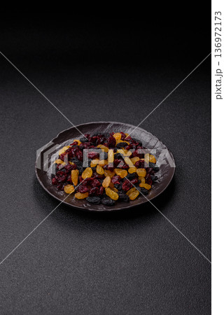 Dried cranberries, yellow and black sweet raisins as ingredients for a breakfast. Raisins and cranberries Dried cranberries, yellow and black sweet raisins as ingredients for a breakfast. Raisins and cranberries 136972173