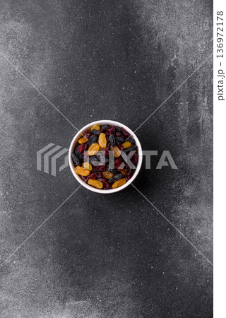 Dried cranberries, yellow and black sweet raisins as ingredients for a breakfast. Raisins and cranberries Dried cranberries, yellow and black sweet raisins as ingredients for a breakfast. Raisins and cranberries 136972178