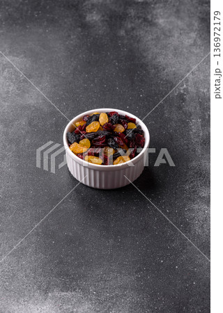 Dried cranberries, yellow and black sweet raisins as ingredients for a breakfast. Raisins and cranberries 136972179