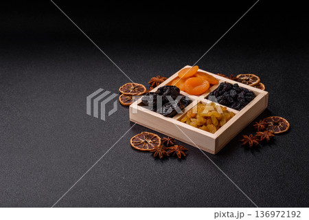 A variety of dried fruits, apricots, prunes, cranberries, raisins, figs, and dates for a healthy breakfast. A dried fruit mix 136972192