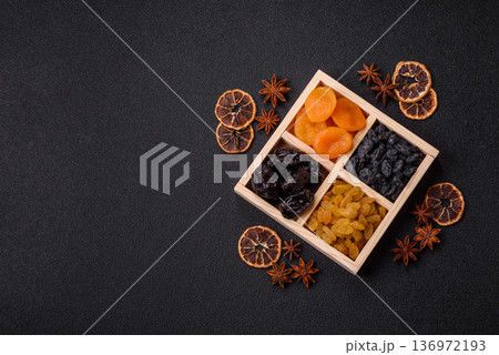 A variety of dried fruits, apricots, prunes, cranberries, raisins, figs, and dates for a healthy breakfast. A dried fruit mix 136972193