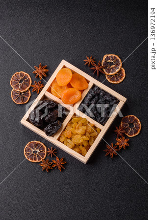A variety of dried fruits, apricots, prunes, cranberries, raisins, figs, and dates for a healthy breakfast. A dried fruit mix 136972194