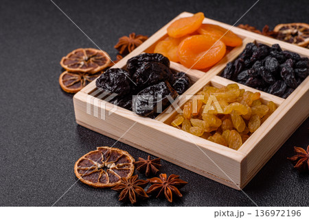 A variety of dried fruits, apricots, prunes, cranberries, raisins, figs, and dates for a healthy breakfast. A dried fruit mix 136972196