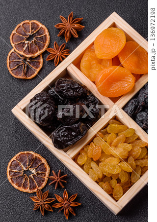 A variety of dried fruits, apricots, prunes, cranberries, raisins, figs, and dates for a healthy breakfast. A dried fruit mix 136972198