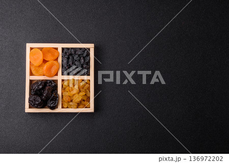 A variety of dried fruits, apricots, prunes, cranberries, raisins, figs, and dates for a healthy breakfast. A dried fruit mix A variety of dried fruits, apricots, prunes, cranberries, raisins, figs, and dates for a healthy breakfast. A dried fruit mix 136972202