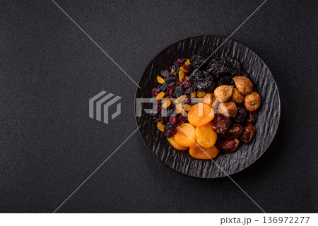 A variety of dried fruits, apricots, prunes, cranberries, raisins, figs, and dates for a healthy breakfast. A dried fruit mix 136972277