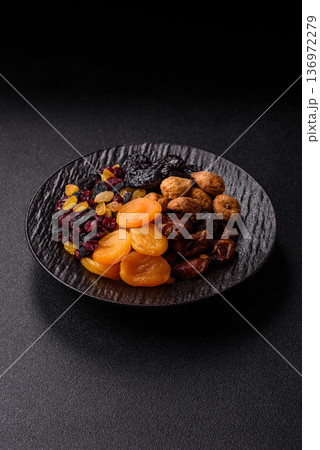 A variety of dried fruits, apricots, prunes, cranberries, raisins, figs, and dates for a healthy breakfast. A dried fruit mix A variety of dried fruits, apricots, prunes, cranberries, raisins, figs, and dates for a healthy breakfast. A dried fruit mix 136972279