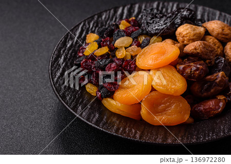 A variety of dried fruits, apricots, prunes, cranberries, raisins, figs, and dates for a healthy breakfast. A dried fruit mix A variety of dried fruits, apricots, prunes, cranberries, raisins, figs, and dates for a healthy breakfast. A dried fruit mix 136972280