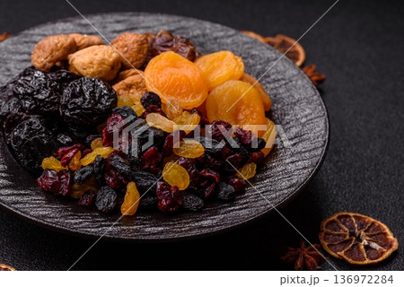 A variety of dried fruits, apricots, prunes, cranberries, raisins, figs, and dates for a healthy breakfast. A dried fruit mix A variety of dried fruits, apricots, prunes, cranberries, raisins, figs, and dates for a healthy breakfast. A dried fruit mix 136972284