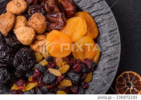 A variety of dried fruits, apricots, prunes, cranberries, raisins, figs, and dates for a healthy breakfast. A dried fruit mix 136972285
