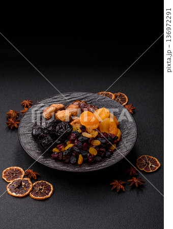 A variety of dried fruits, apricots, prunes, cranberries, raisins, figs, and dates for a healthy breakfast. A dried fruit mix 136972291