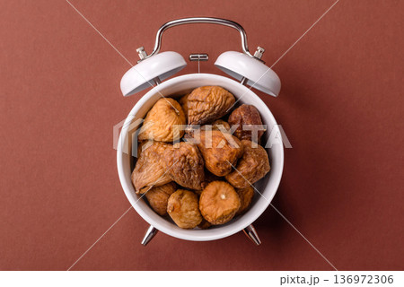 Vintage alarm clock on brown surface as a conceptual background for deadlines for tasks 136972306
