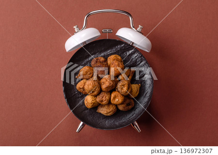 Vintage alarm clock on brown surface as a conceptual background for deadlines for tasks 136972307