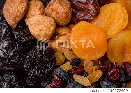 A variety of dried fruits, apricots, prunes, cranberries, raisins, figs, and dates for a healthy breakfast. A dried fruit mix 136972409