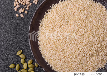 White sesame seeds in a bowl, an ingredient for oil and healthy eating. White sesame White sesame seeds in a bowl, an ingredient for oil and healthy eating. White sesame 136972845