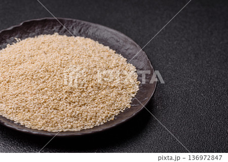 White sesame seeds in a bowl, an ingredient for oil and healthy eating. White sesame White sesame seeds in a bowl, an ingredient for oil and healthy eating. White sesame 136972847