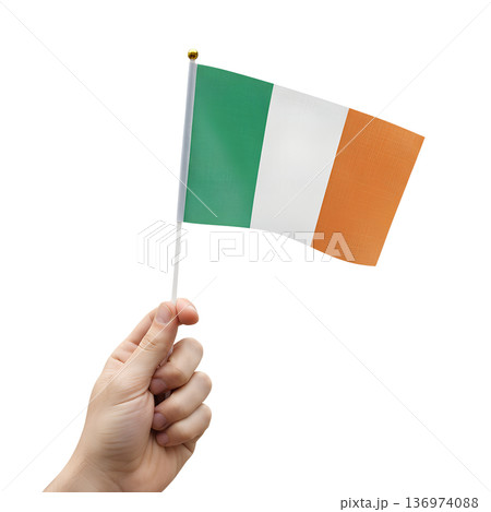 Hand holding a small irish flag on a transparent background. Perfect for st. patrick's day celebrations, irish pride, and cultural events 136974088