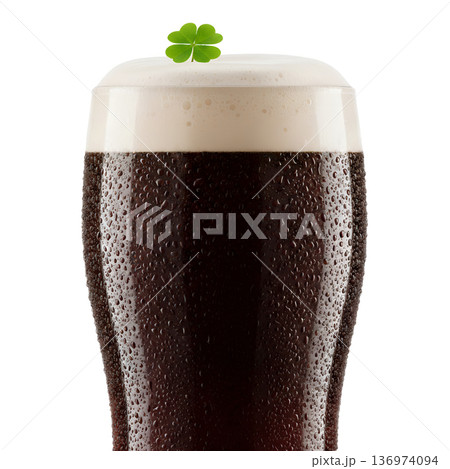 Frosty pint glass of dark stout beer with a foamy head topped with a green shamrock, perfect for st. patrick's day pub celebrations Frosty pint glass of dark stout beer with a foamy head topped with a green shamrock, perfect for st. patrick's day pub celebrations 136974094