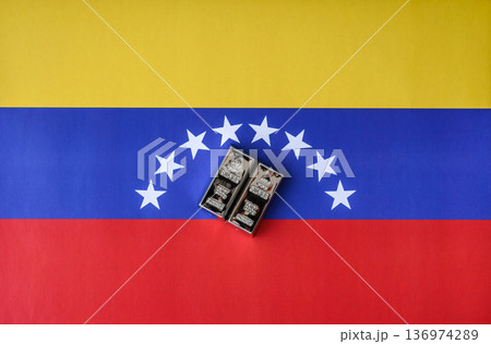 A silver bar, white metal against a flag of venezuela, as a concept for the sales. A silver bar 136974289