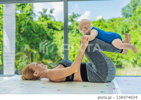 Mother doing fitness exercises while holding her baby at home, combining workout and childcare. Real lifestyle moment showing balance, strength and love. Postpartum fitness, healthy motherhood and Mother doing fitness exercises while holding her baby at home, combining workout and childcare. Real lifestyle moment showing balance, strength and love. Postpartum fitness, healthy motherhood and 136974634