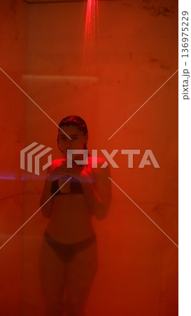 Expressive dancer recovering after practice under warm red steam light Expressive dancer recovering after practice under warm red steam light 136975229