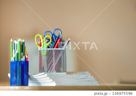 Stack of notebooks, colorful drawing pencils and stationery arrangement on copy space background. Stack of notebooks, colorful drawing pencils and stationery arrangement on copy space background. 136975596
