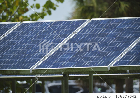 Solar photovoltaic panels mounted on stand-alone frame on backyard ground for generating of clean ecological electric energy. Concept of autonomous house 136975642