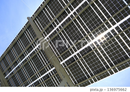 Solar panels installed as shade roof over parking lot for parked electric cars for effective generation of clean electricity. Photovoltaic technology integrated in urban infrastructure Solar panels installed as shade roof over parking lot for parked electric cars for effective generation of clean electricity. Photovoltaic technology integrated in urban infrastructure 136975662