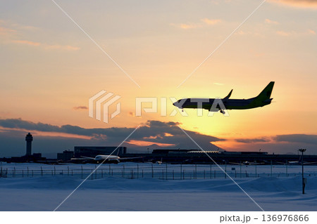 夕焼けをバックに着陸する機影「冬の新千歳空港」 夕焼けをバックに着陸する機影「冬の新千歳空港」 136976866