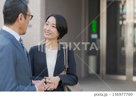 雑談をするスーツの男女 136977700