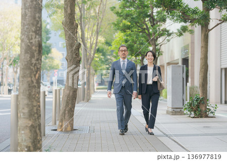 オフィス街を歩くスーツの男女 136977819