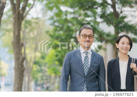 オフィス街を歩くスーツの男女 オフィス街を歩くスーツの男女 136977825