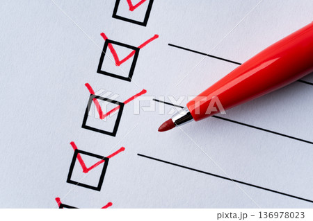赤いペンでレ点を記入したチェック欄のクローズアップ 136978023