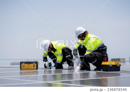Solar panel installer engineer team installing photovoltaic system renewable energy power rooftop. 136978540