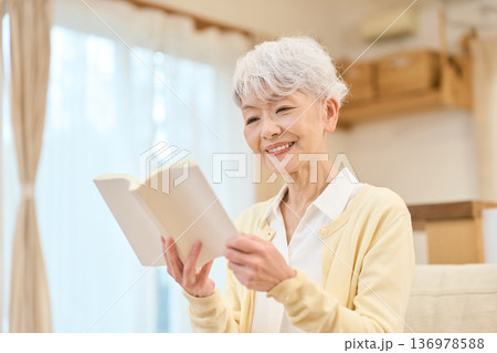 リビングで読書をするアジア人シニア女性 リビングで読書をするアジア人シニア女性 136978588