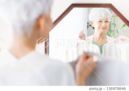 鏡の前で洋服選びをするシニア女性 鏡の前で洋服選びをするシニア女性 136978646