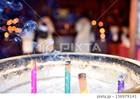 お寺の線香越しに見える参拝者 136979143