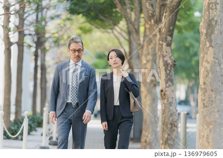 並木道を歩くスーツの男女 136979605