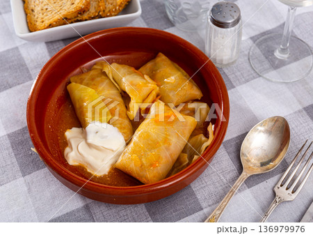Stuffed cabbage rolls served with cream sauce 136979976