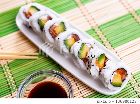 Japanese Uramaki and California rolls served in a plate with soya sauce Japanese Uramaki and California rolls served in a plate with soya sauce 136980125