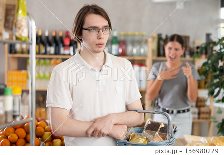 Young woman quarrels with man in grocery store Young woman quarrels with man in grocery store 136980229
