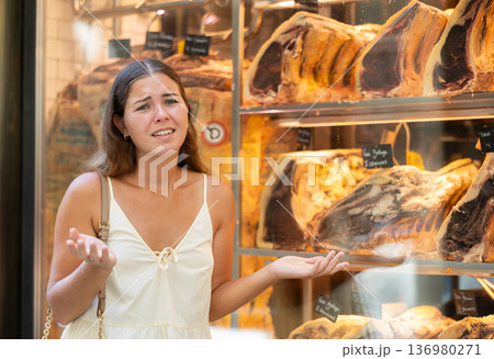 Young girl expresses dissatisfaction and protest at the sight of exquisite aged beef on display at an expensive restaurant 136980271