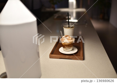 Dessert and iced coffee on wooden tray in modern cafe 136980626