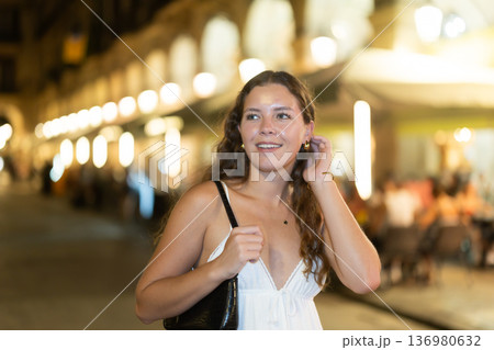 young woman walks along an evening street in Barcelona young woman walks along an evening street in Barcelona 136980632
