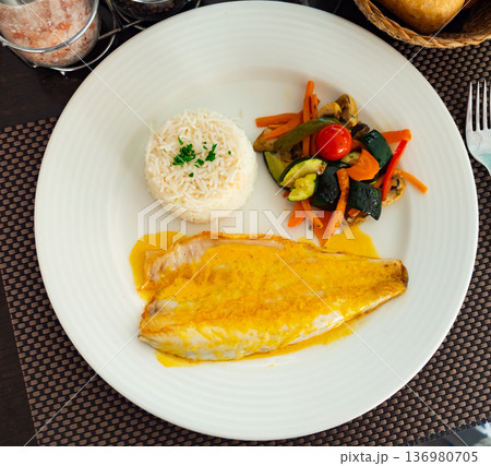 Sea bass fillet with curry sauce and basmati rice 136980705