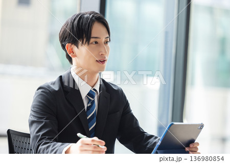 タブレットを見るビジネスマン 136980854