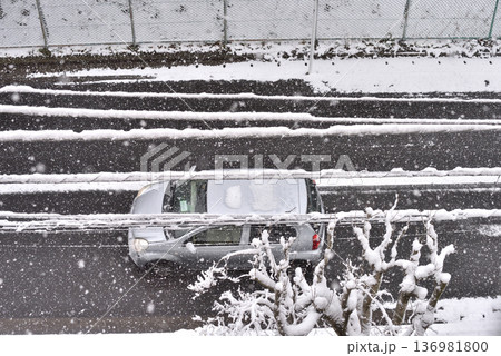 雪の降り積もった道路を走るクルマ 雪の降り積もった道路を走るクルマ 136981800