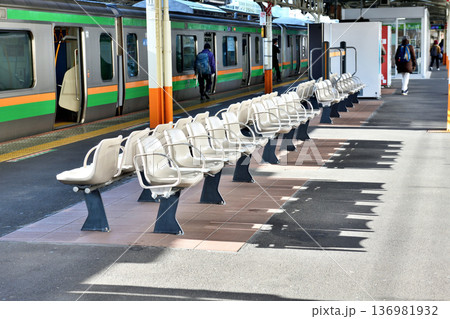 早朝の日差しで影が長いJR熱海駅ホームのベンチ 早朝の日差しで影が長いJR熱海駅ホームのベンチ 136981932