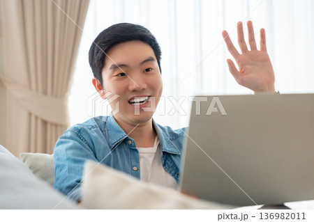 Young Asian man relaxing on comfortable couch 136982011