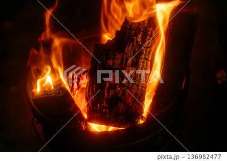 薪が赤々と燃える力強い炎のクローズアップ。自然の中での焚き火やエネルギーの躍動感を感じさせる横位置素 136982477
